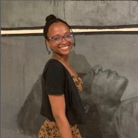 headshot in front of painting at opening night at the Olympia gallery