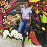 Female standing in front of a mural in Waterlane in downtown Kingston 