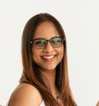 smiling woman with dark brown hair and glasses