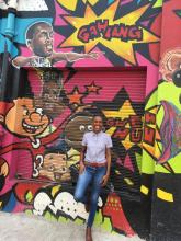 Female standing in front of a mural in Waterlane in downtown Kingston 